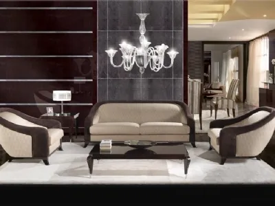 salotto con divani color panna con bordi in velluto marrone, tavolino nero e lampadario in vetro trasparente