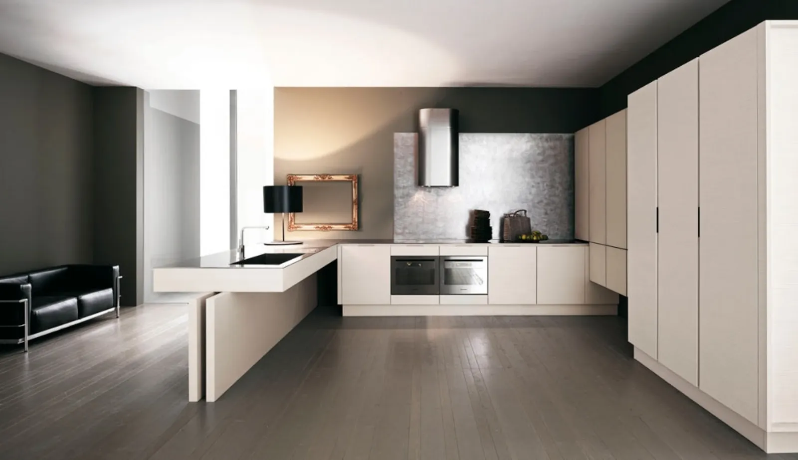 cucina con mobili e penisola e cappa total white, divano in pelle